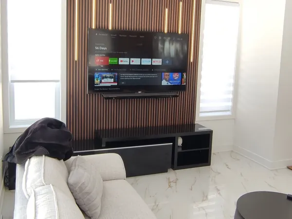 TV et barre de son sur mur de lattes éclairé