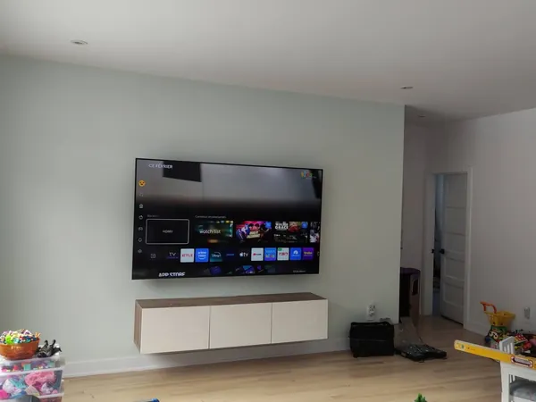 Grande TV au-dessus d'un meuble flottant